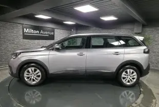 Profil côté gauche du Peugeot 5008 gris métallisé, SUV familial 7 places en intérieur showroom.