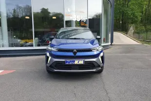 Vue avant d'un Renault Captur bleu Iron 2026 avec calandre moderne et éclairage LED distinctif, stationné devant un showroom.