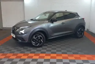 Nissan Juke Hybrid 143 Business+ gris foncé, vue 3/4 avant droit, jantes noires à motifs argentés.