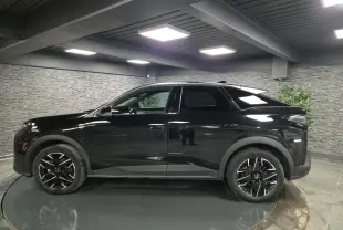 Peugeot 3008 noir en profil droit dans un intérieur, avec jantes alliage noires et détails noirs mats.