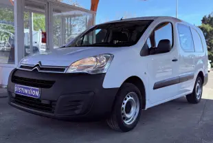 Vue 3/4 avant droite d'un Citroën Berlingo blanc avec pare-chocs noir et jantes acier sous un abri.