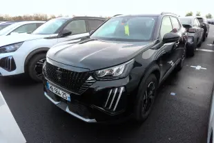 Peugeot 2008 noir vue 3/4 avant droit, avec calandre noire et feux LED distinctifs, stationnée sur parking.