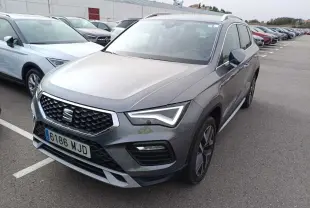 SEAT Ateca gris foncé métal vu en 3/4 avant droit sur un parking, avec calandre et phares LED distinctifs.