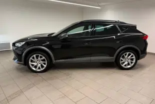 Profil côté gauche d'un CUPRA Formentor 1.5 TSI noir minuit 2024, avec jantes argentées et lignes dynamiques marquées.