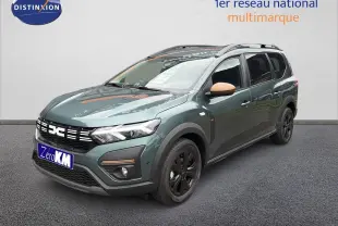 Vue 3/4 avant d'un Dacia Jogger 2026 vert cèdre métallisé avec rétroviseurs couleur beige et jantes noires.