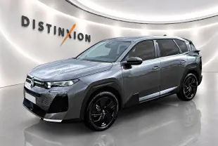 Vue 3/4 avant d'un Citroën C5 Aircross gris platinium avec jantes alliage noires dans un showroom lumineux.
