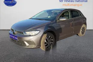 Volkswagen Polo gris vue 3/4 avant droit avec jantes alu et phares LED allumés sur fond clair.