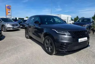 Range Rover Velar gris tempête vu en 3/4 avant droit avec jantes satinées et calandre noire brillante.