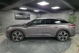 Profil côté gauche d'une Citroën C5 X hybride rechargeable gris métallisé avec jantes alliage 19 pouces AeroX.