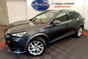 Vue 3/4 avant d'un CUPRA Formentor gris foncé avec jantes argentées dans un showroom intérieur.