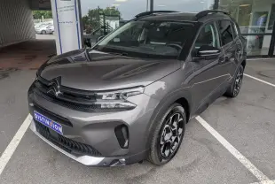 Vue 3/4 avant droite du Citroën C5 Aircross hybride gris platinium avec jantes biton 18 pouces et toit panoramique.