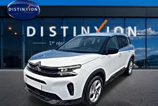 Citroën C5 Aircross blanc vue 3/4 avant droit avec calandre noire brillante devant un bâtiment Distinxion.