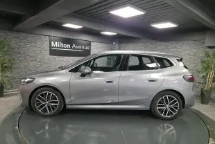 BMW Série 2 Active Tourer gris métallisé vue de profil côté gauche avec jantes alliage et poignées affleurantes.