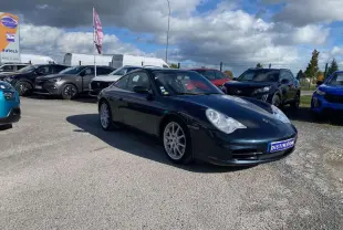 Porsche 911 Targa 3.6i 2004 gris foncé vue 3/4 avant droit sur parking extérieur sous ciel nuageux.