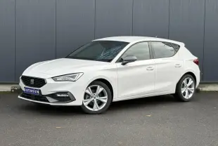 Vue 3/4 avant droite d'une SEAT Leon 1.5 e-TSI 150 DSG7 FR blanche avec jantes alliage 17 pouces et vitres surteintées.