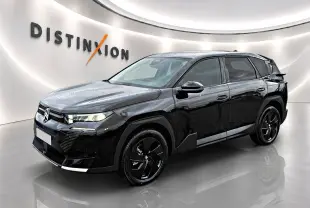 Vue 3/4 avant d'un Citroën C5 Aircross noir brillant avec jantes alliage noires dans un showroom.