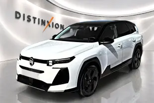 Vue 3/4 avant d'un Citroën C5 Aircross blanc à toit noir avec jantes alliage noires dans un showroom.