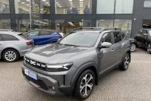 Dacia Duster 1.6 Hybrid 140 cv Journey gris schiste en 3/4 avant droit, avec jantes alliage et toit ouvrant.