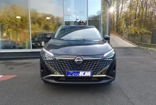 Vue avant d'un Nissan Qashqai noir 2025 avec calandre texturée et phares LED fins, stationné devant une vitrine.