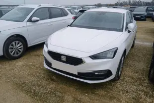 SEAT Leon blanc vue 3/4 avant droite, avec calandre hexagonale et phares LED anguleux sur parking extérieur.