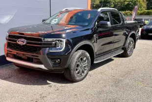 Ford Ranger 3.0 V6 Wildtrak Plus noir agate vu en 3/4 avant droit avec jantes alu et marchepieds visibles.