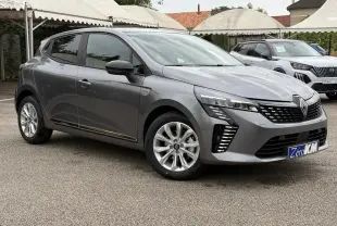 Renault Clio V gris schiste vue 3/4 avant droit, avec feux LED et jantes alliage 16 pouces visibles.