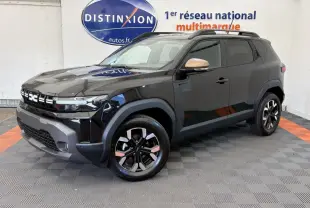 Dacia Duster noir en 3/4 avant droit, avec jantes bicolores et rétroviseurs couleur bronze, sur fond intérieur showroom.