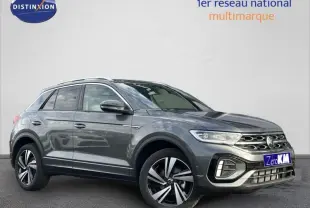 Volkswagen T-Roc gris en 3/4 avant droit, finition R-Line avec jantes alliage distinctives et calandre chromée.