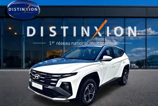Hyundai Tucson blanc en 3/4 avant droit, avec calandre noire et jantes alliage 17 pouces visibles.
