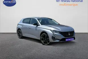 Peugeot 308 gris métallisé vue 3/4 avant droit, avec jantes noires et signature lumineuse LED verticale.