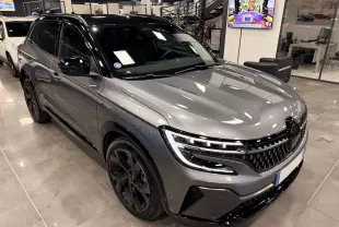 Renault Austral E-Tech gris schist avec toit noir, vue 3/4 avant droit mettant en valeur ses phares LED et jantes noires.