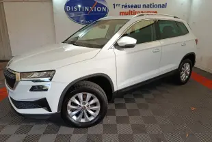Vue 3/4 avant droite d'un SUV SKODA KAROQ blanc, avec jantes alliage et rétroviseurs assortis.