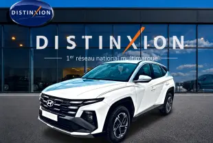 Hyundai Tucson blanc 2026 en 3/4 avant droit, avec calandre noire distinctive et jantes alliage 17 pouces.