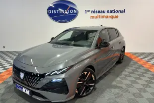 Peugeot 308 III Ph.2 Hybrid 145 GT gris Selenium vue 3/4 avant droit en showroom avec jantes noires bicolores.