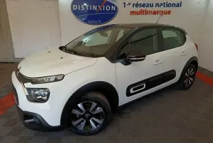 Citroën C3 blanche vue 3/4 avant droit, avec protections latérales noires et jantes bicolores.
