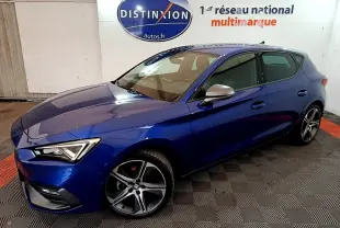 SEAT Leon 1.5 eTSI bleu en vue 3/4 avant droit, avec jantes alliage et rétroviseurs argentés dans un showroom.