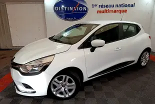 Renault Clio Business TCe 90 blanche vue de 3/4 avant droit, avec jantes alliage et feux LED, en intérieur showroom.