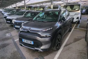 Citroën C3 Aircross gris foncé vue 3/4 avant droit, avec jantes alliage et toit noir brillant sous abri.