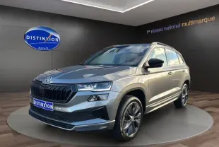 SUV Skoda Karoq gris graphite en 3/4 avant droit, avec jantes alliage noires et calandre marquée.