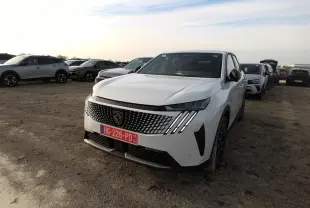 Peugeot 3008 blanc vue 3/4 avant avec calandre à motif géométrique et feux LED griffés, sur parking extérieur.