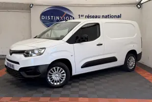 Vue 3/4 avant droit d'un Toyota Proace City blanc, fourgon utilitaire avec protections noires sur les bas de caisse et pare-chocs.