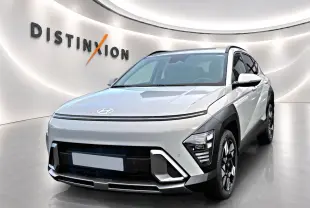 Vue 3/4 avant d'un Hyundai Kona gris avec calandre fermée et jantes alliage noires et argentées dans un showroom.