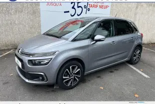 Citroën C4 SpaceTourer gris vue 3/4 avant droit sur parking, avec jantes alliage et calandre distinctive.