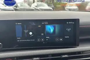 Écran tactile du tableau de bord du Hyundai Tucson blanc sérénité, affichant navigation et options hybrides.