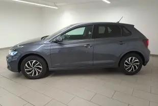 Volkswagen Polo gris cendre vue de profil côté gauche dans un intérieur lumineux avec jantes distinctives.