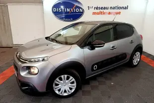 Citroën C3 gris clair vue 3/4 avant droit, avec protections latérales noires et jantes acier.