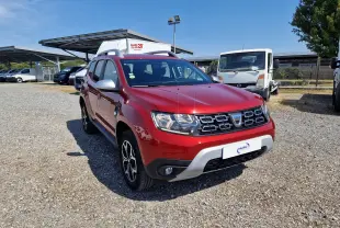 Dacia Duster rouge fusion en 3/4 avant droit, avec calandre noire et jantes alliage noires et argent.