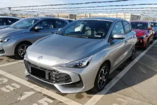 MG3 1.5 Hybrid+ 195 Luxury argent Cosmic en 3/4 avant droit, avec calandre large et jantes alliage 16 pouces.