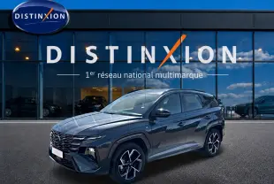 Hyundai Tucson 2026 gris ecotronique en 3/4 avant droit, avec calandre glossy black et jantes alliage 19 pouces.