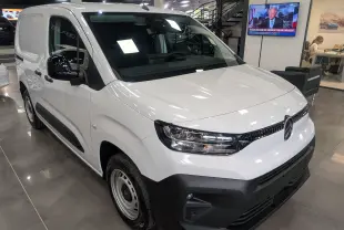 Vue 3/4 avant gauche d'un Citroën Berlingo Van blanc 2025 avec pare-chocs noir mat et rétroviseurs noirs en concession.